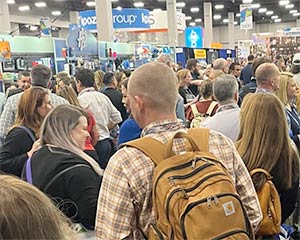 Amidst a trade show crowd, one attendee stands out with a branded backpack.